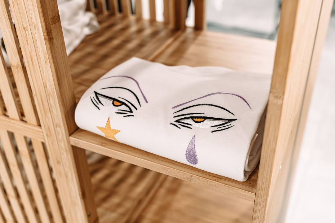 un t-shirt oversize Hisoka de hxh posé sur une étagère